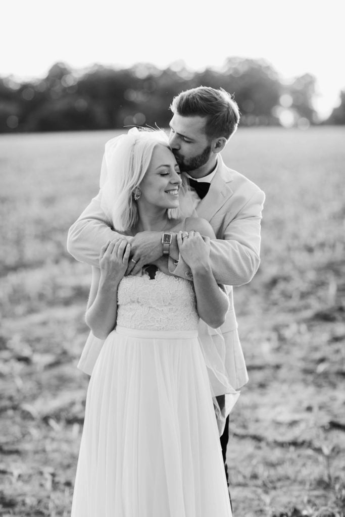 Golden hour black and white bride and groom in field in Illinois by Geneva Wedding Photographer