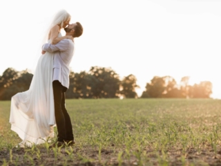 Golden hour in field in Illinois groom lifting bride by Geneva Wedding Photographer