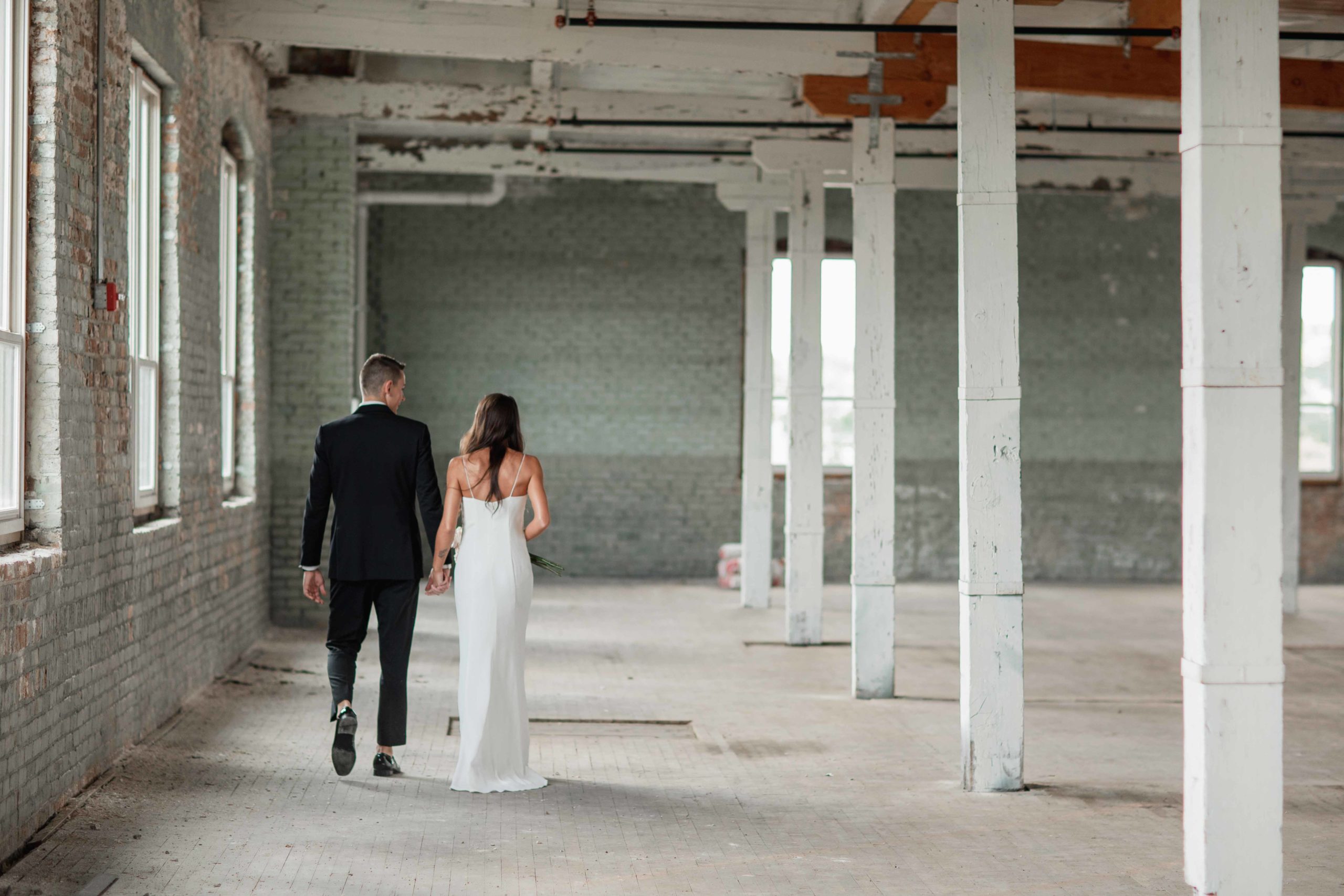 Company 251 Geneva Wedding Photographer bride and groom walking in empty warehouse